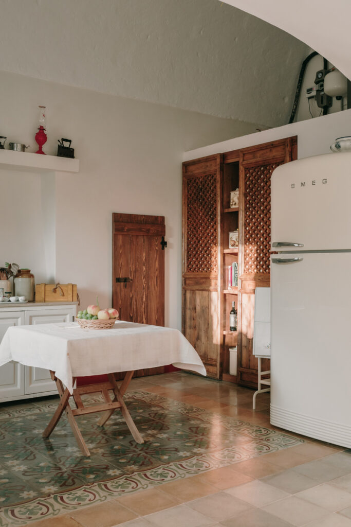 La cuisine intérieure, entre classicisme et modernité. Les mus sont en enduit chaux blancs, les meubles en bois et le frigo SMEG beige.